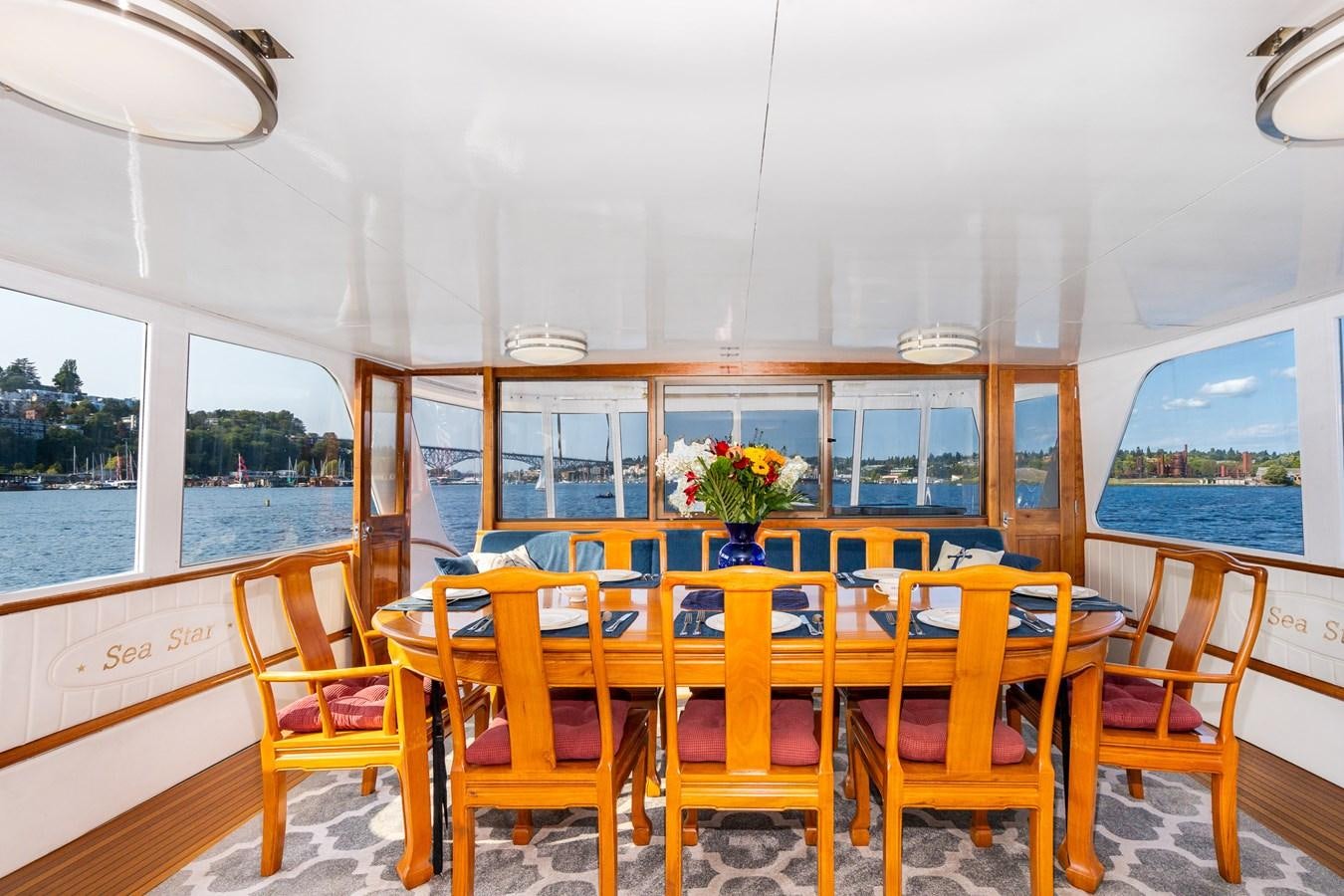 a dining table with chairs and a view of the water aboard SEA STAR Yacht for Sale