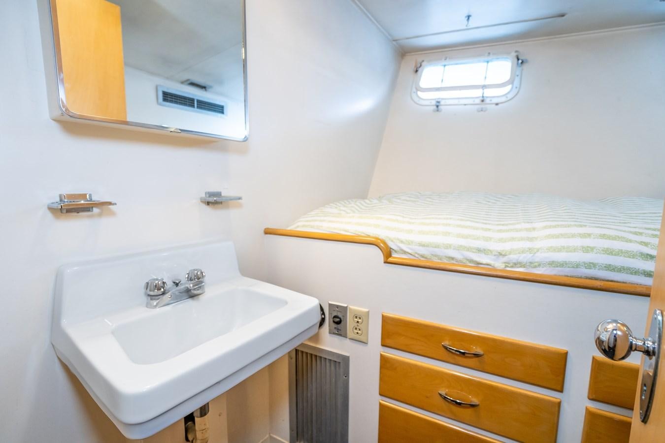 a bathroom with a sink and a bed aboard SEA STAR Yacht for Sale