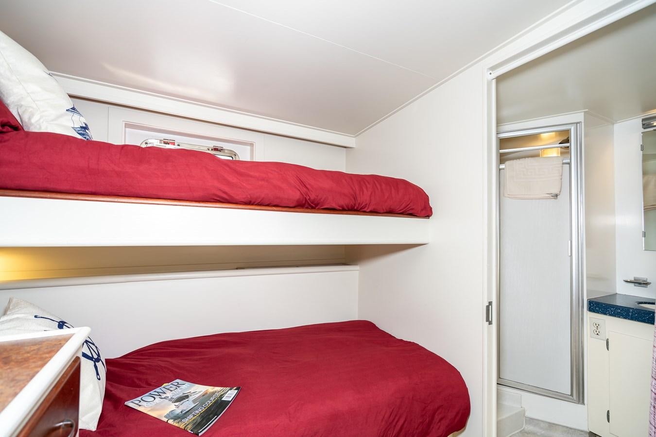 a bed with a red pillow aboard SEA STAR Yacht for Sale