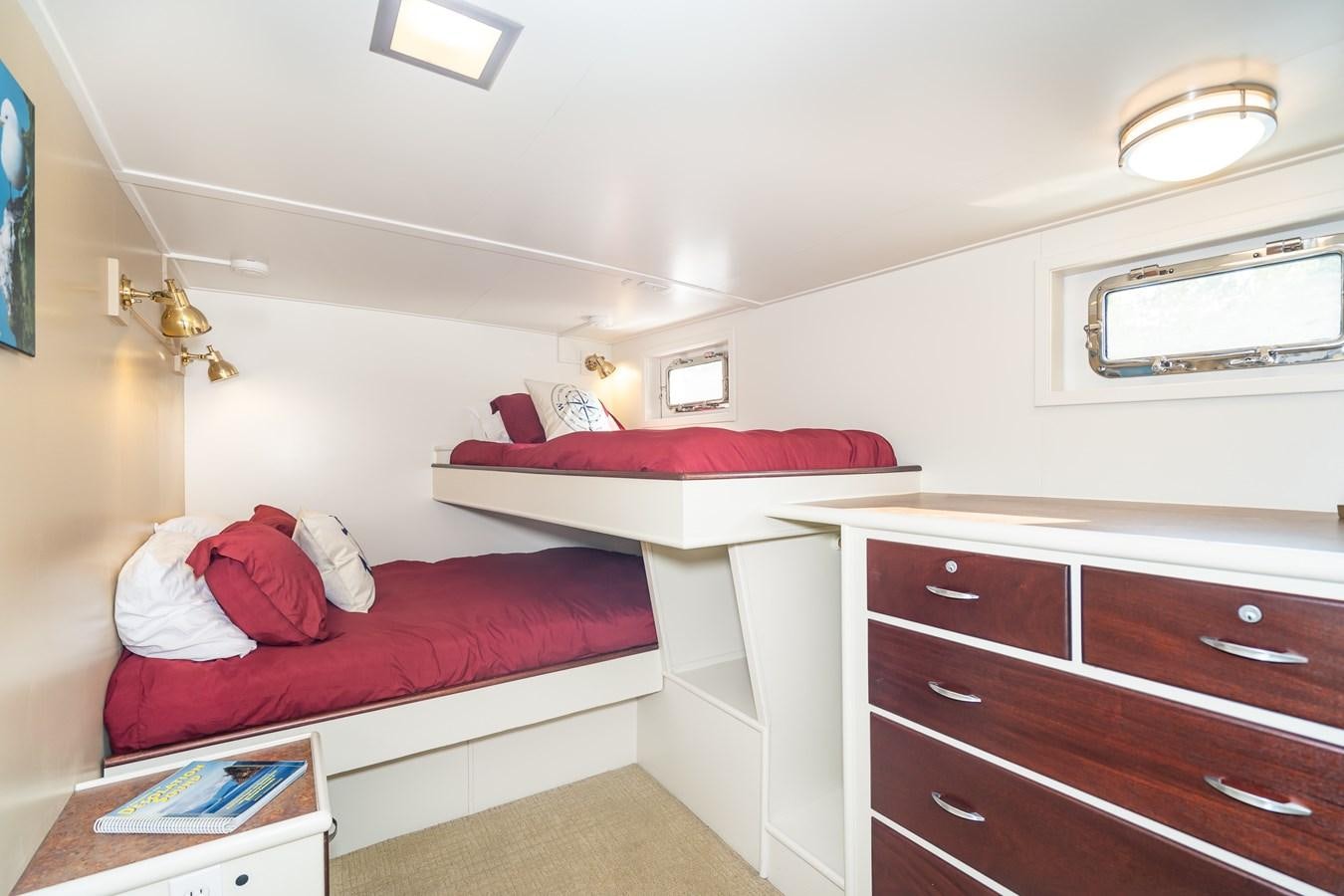 a bedroom with a red bed and a white pillow aboard SEA STAR Yacht for Sale