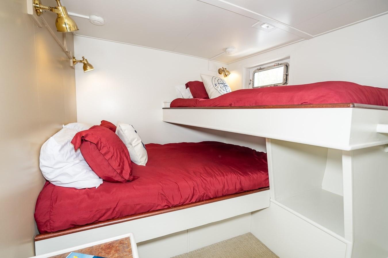 a bed with red pillows aboard SEA STAR Yacht for Sale