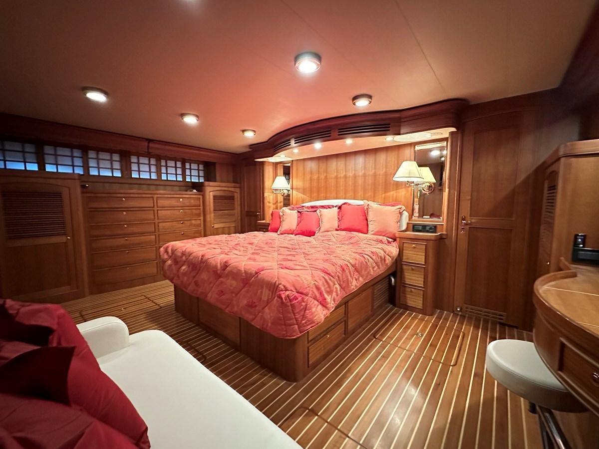 a bedroom with a bed and a desk aboard AZURA Yacht for Sale