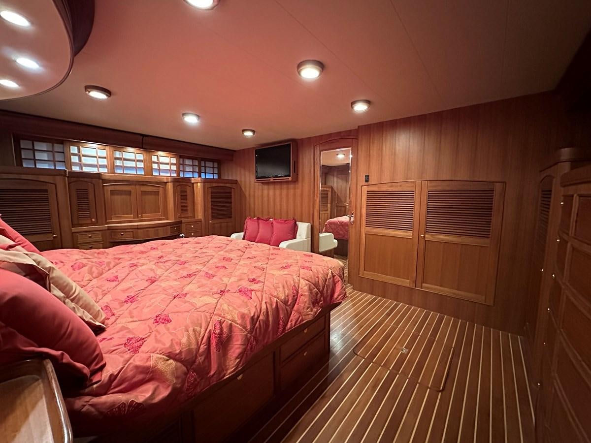 a bedroom with a bed and a wood door aboard AZURA Yacht for Sale