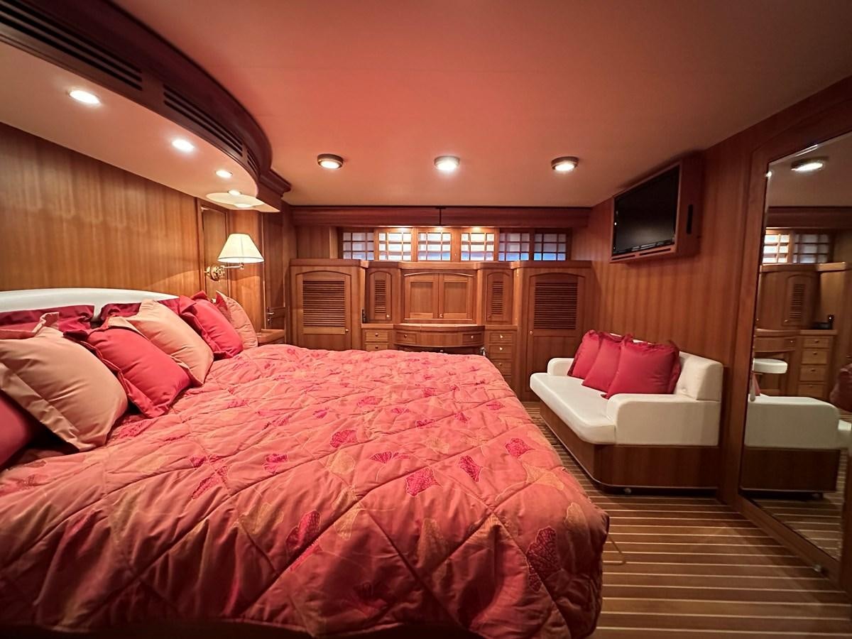 a bedroom with a bed and a couch aboard AZURA Yacht for Sale