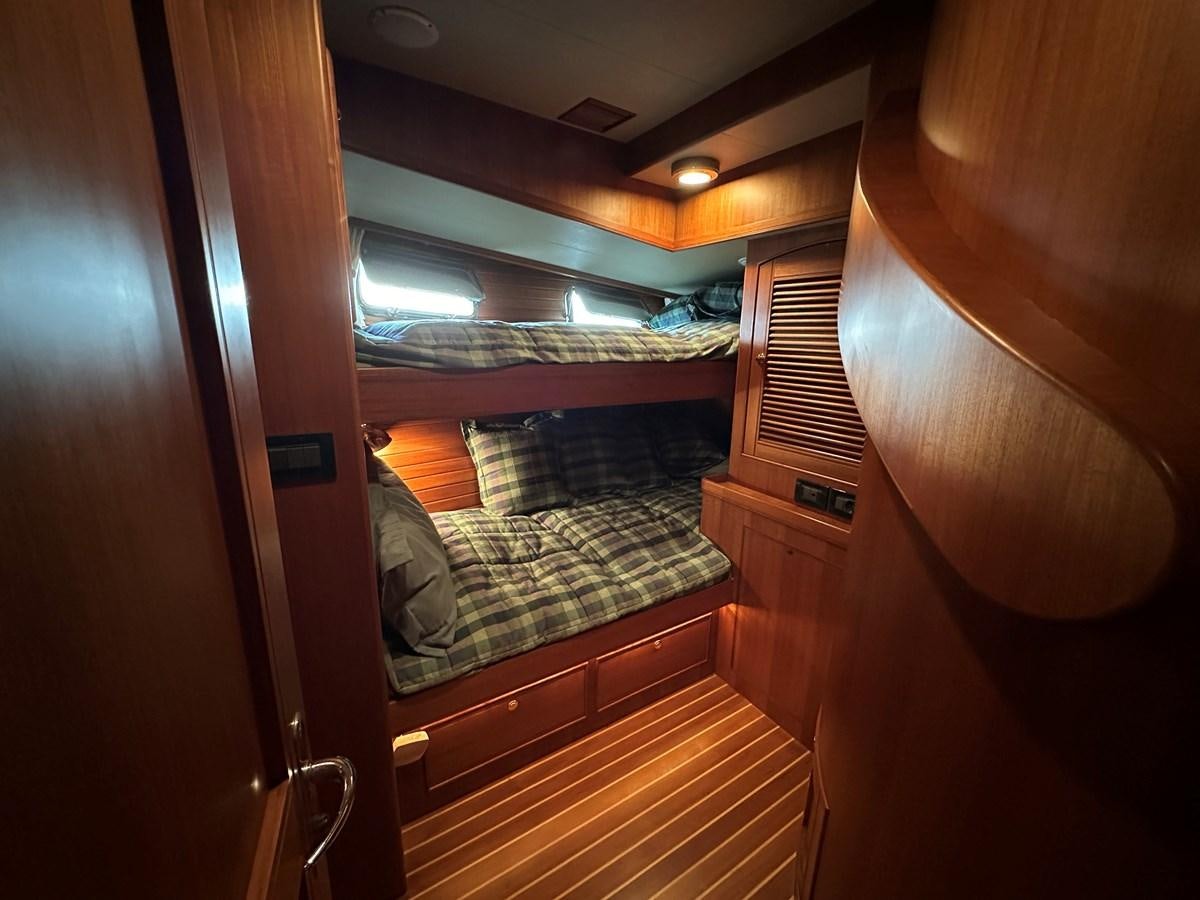 a room with a bed and a mirror aboard AZURA Yacht for Sale