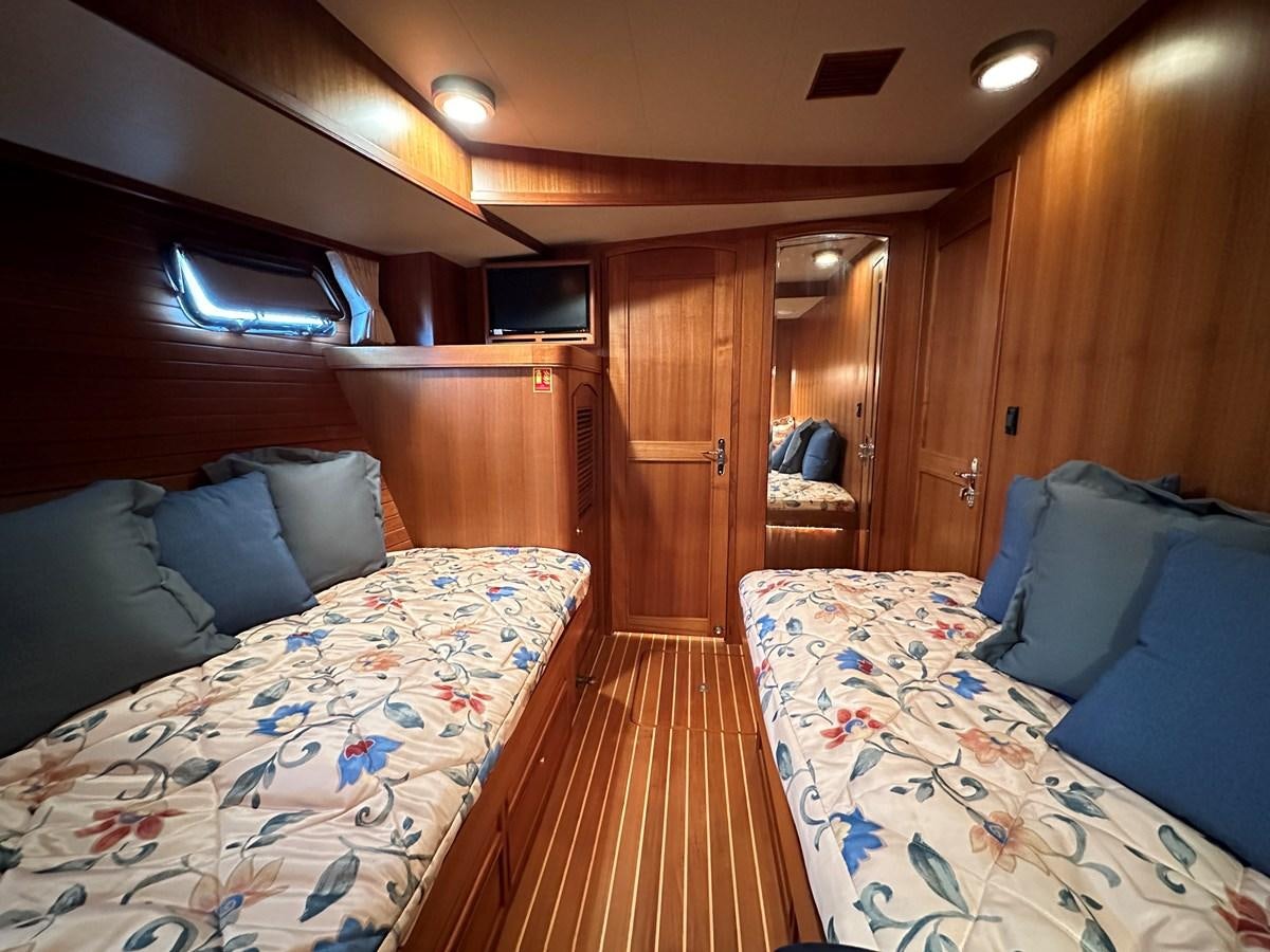a room with a bed and a wood door aboard AZURA Yacht for Sale