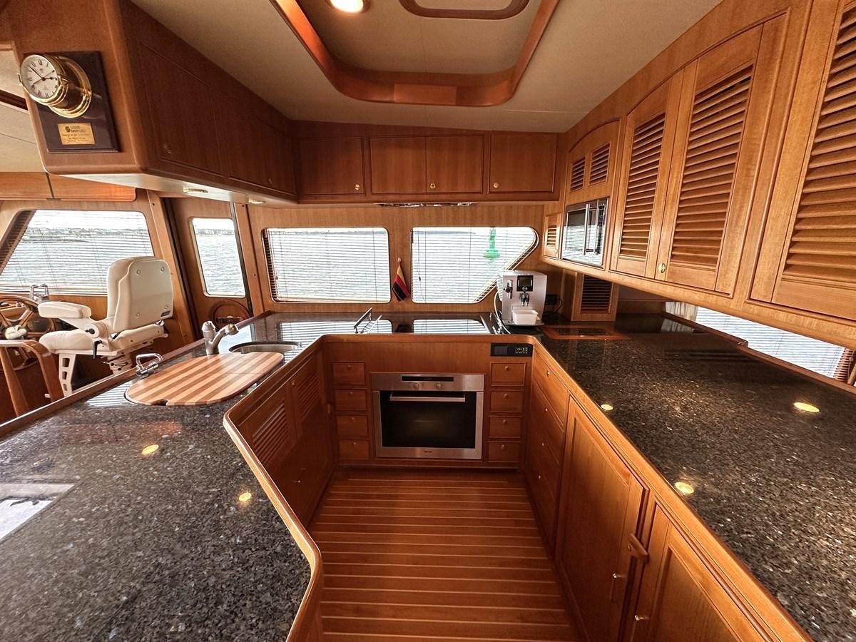 a kitchen with wooden cabinets aboard AZURA Yacht for Sale