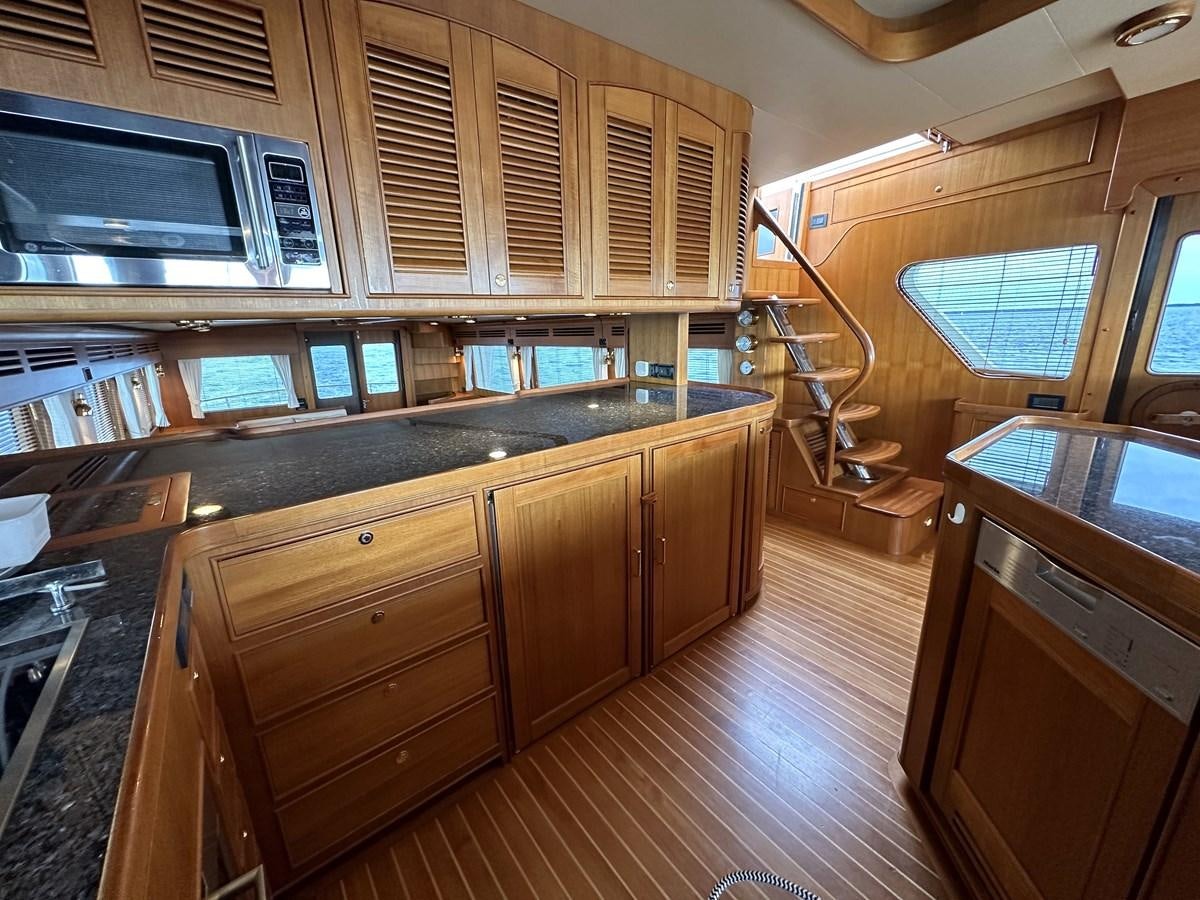 a kitchen with wooden cabinets aboard AZURA Yacht for Sale
