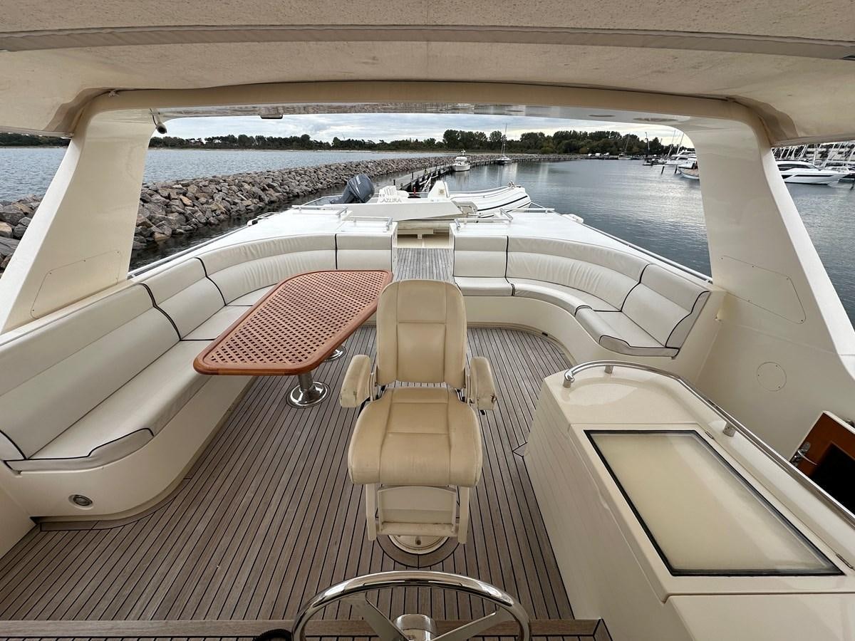a chair on a deck overlooking a body of water aboard AZURA Yacht for Sale