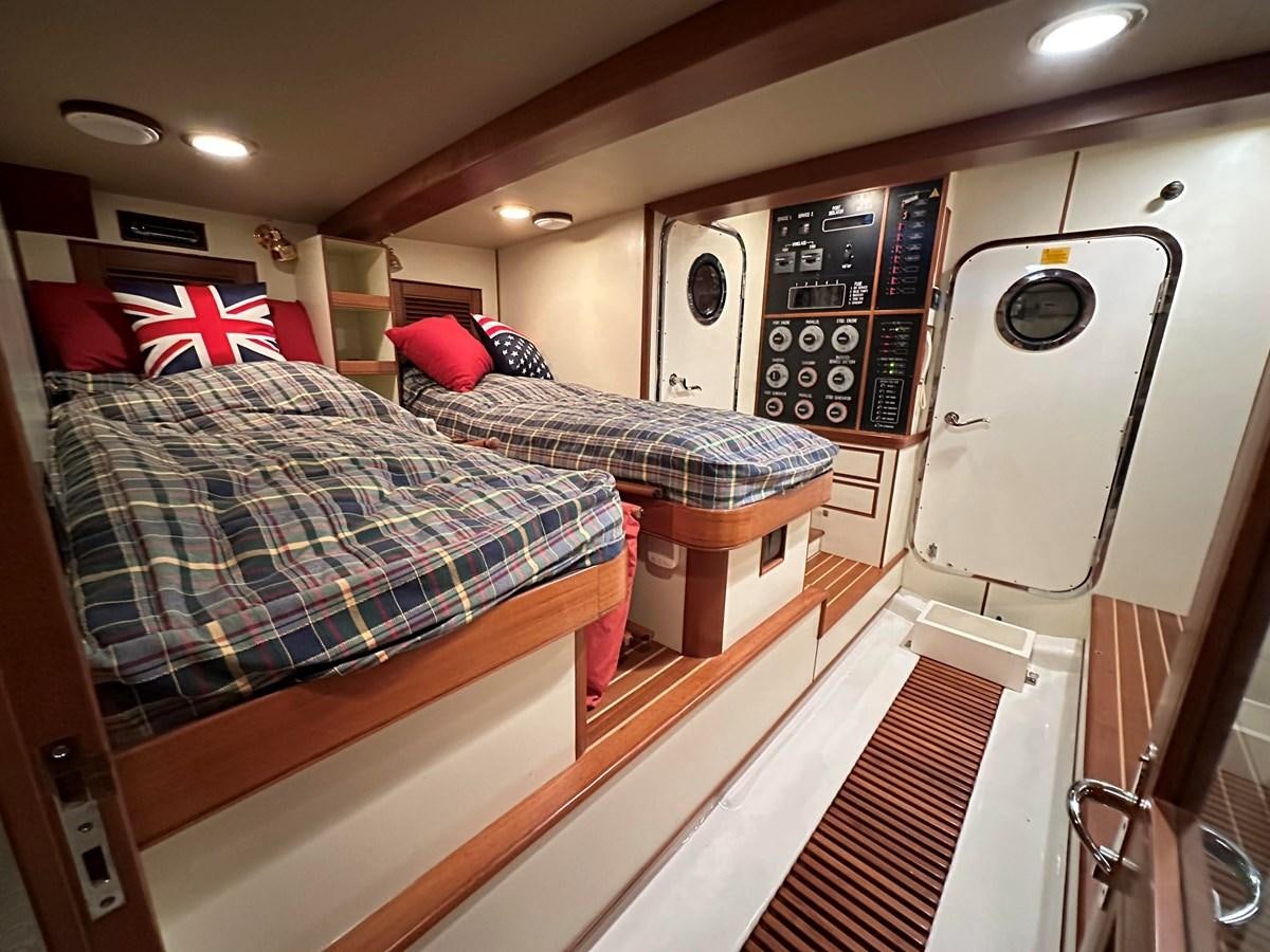 a room with a bed and a television aboard AZURA Yacht for Sale