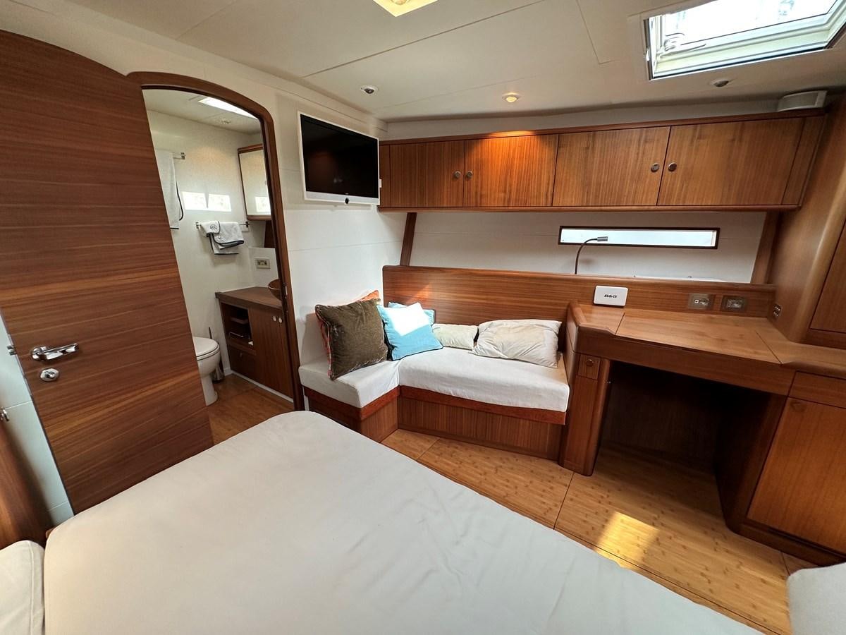 a room with a bed and a tv on the wall aboard REGINA Yacht for Sale