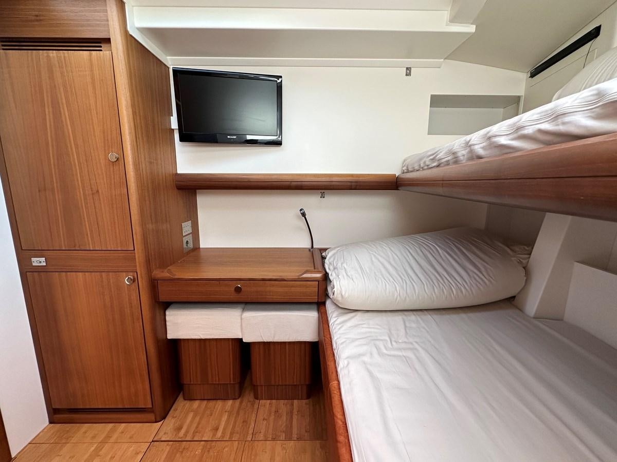 a room with a bed and a television aboard REGINA Yacht for Sale
