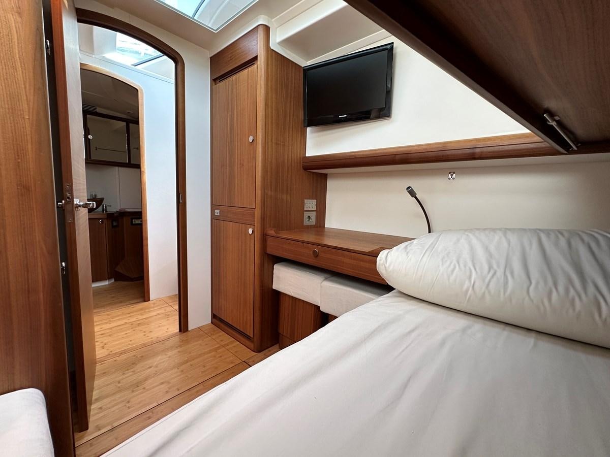 a bedroom with a bed and a television aboard REGINA Yacht for Sale