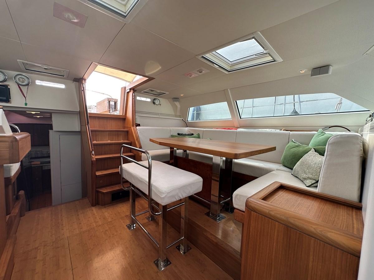a room with a table and couch aboard REGINA Yacht for Sale