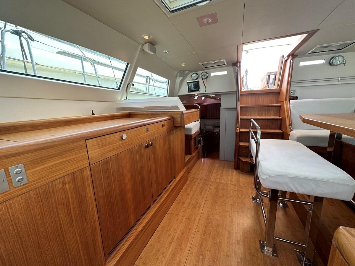 a room with a wood floor and a wood cabinet and a table aboard REGINA Yacht for Sale