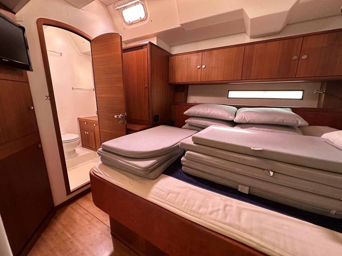 a room with a bed and a television aboard REGINA Yacht for Sale
