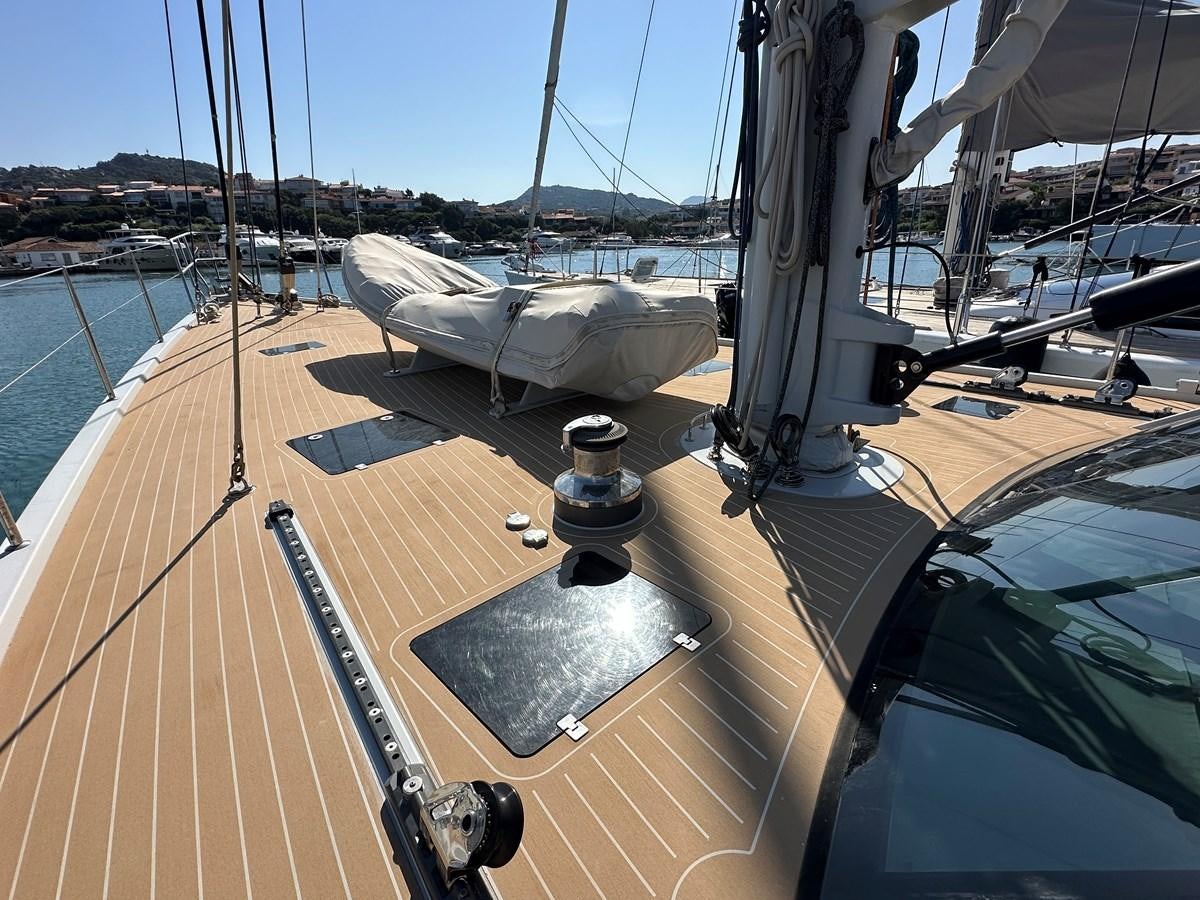 a deck with a boat and a deck with a railing and a body of water and buildings in aboard REGINA Yacht for Sale