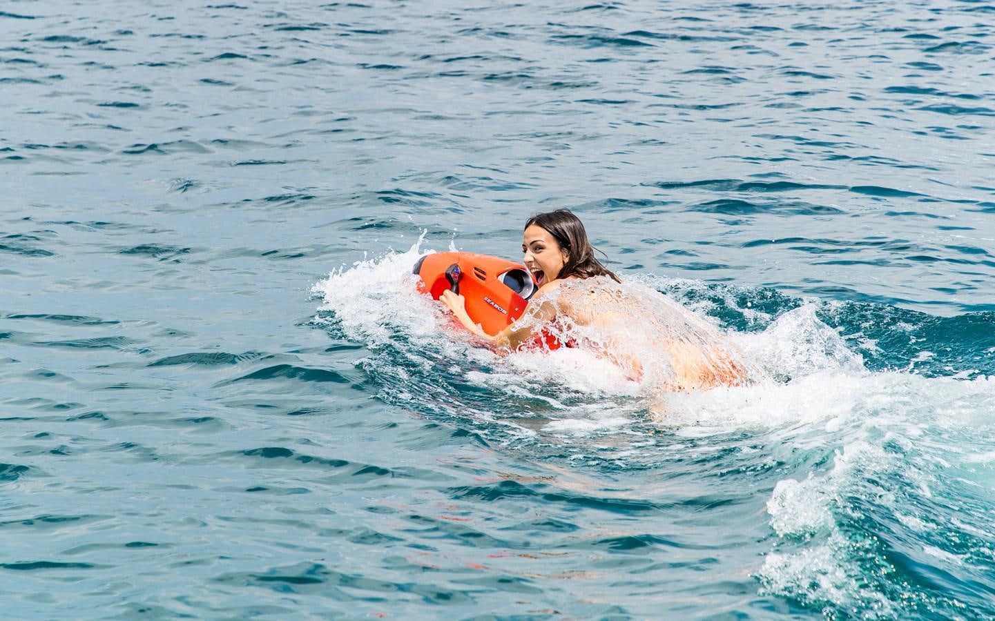 a person riding a surfboard aboard PARODIA Yacht for Sale