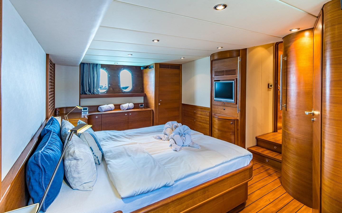 a bedroom with a bed and a television aboard PARODIA Yacht for Sale