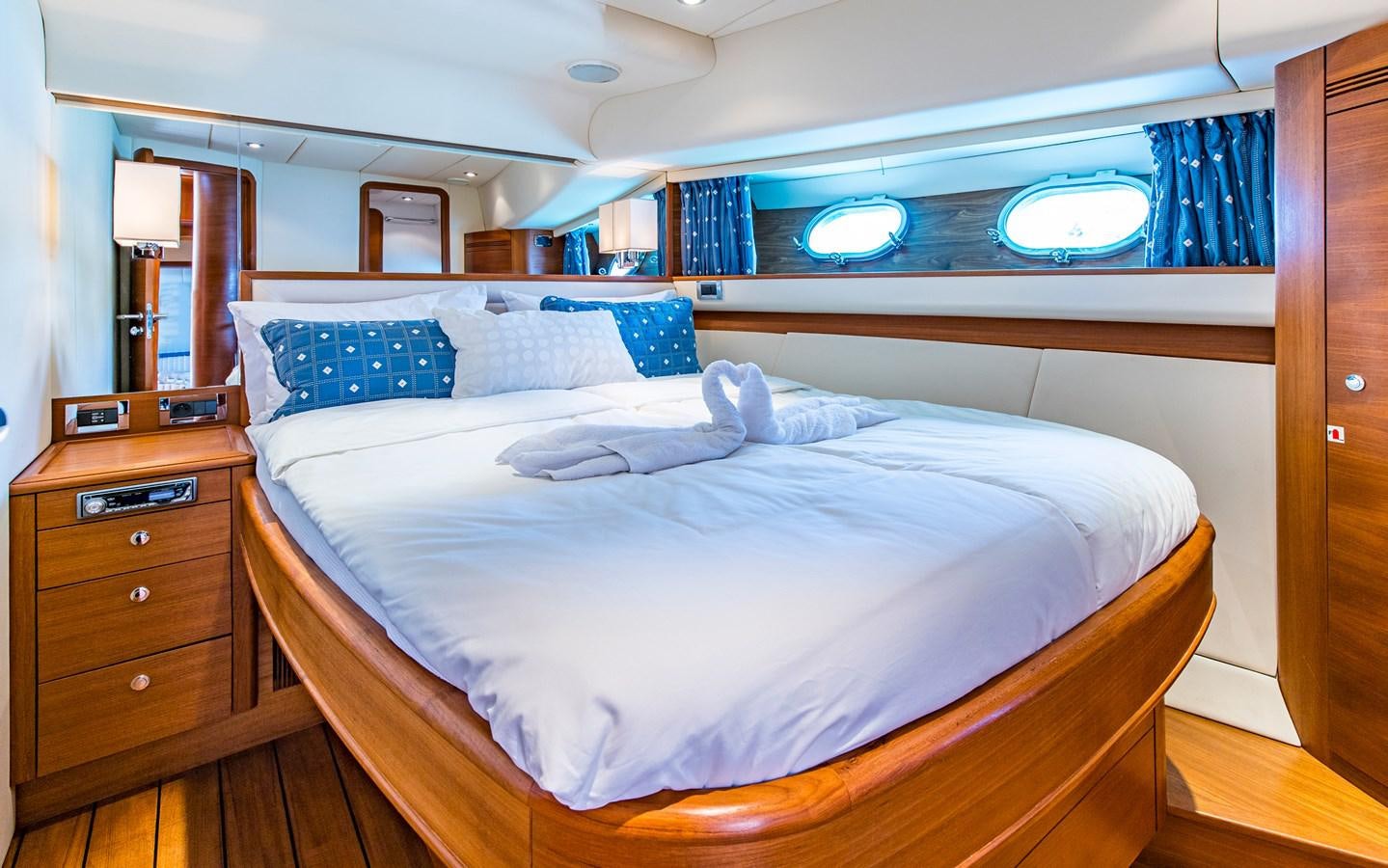a bed with a blue pillow aboard PARODIA Yacht for Sale