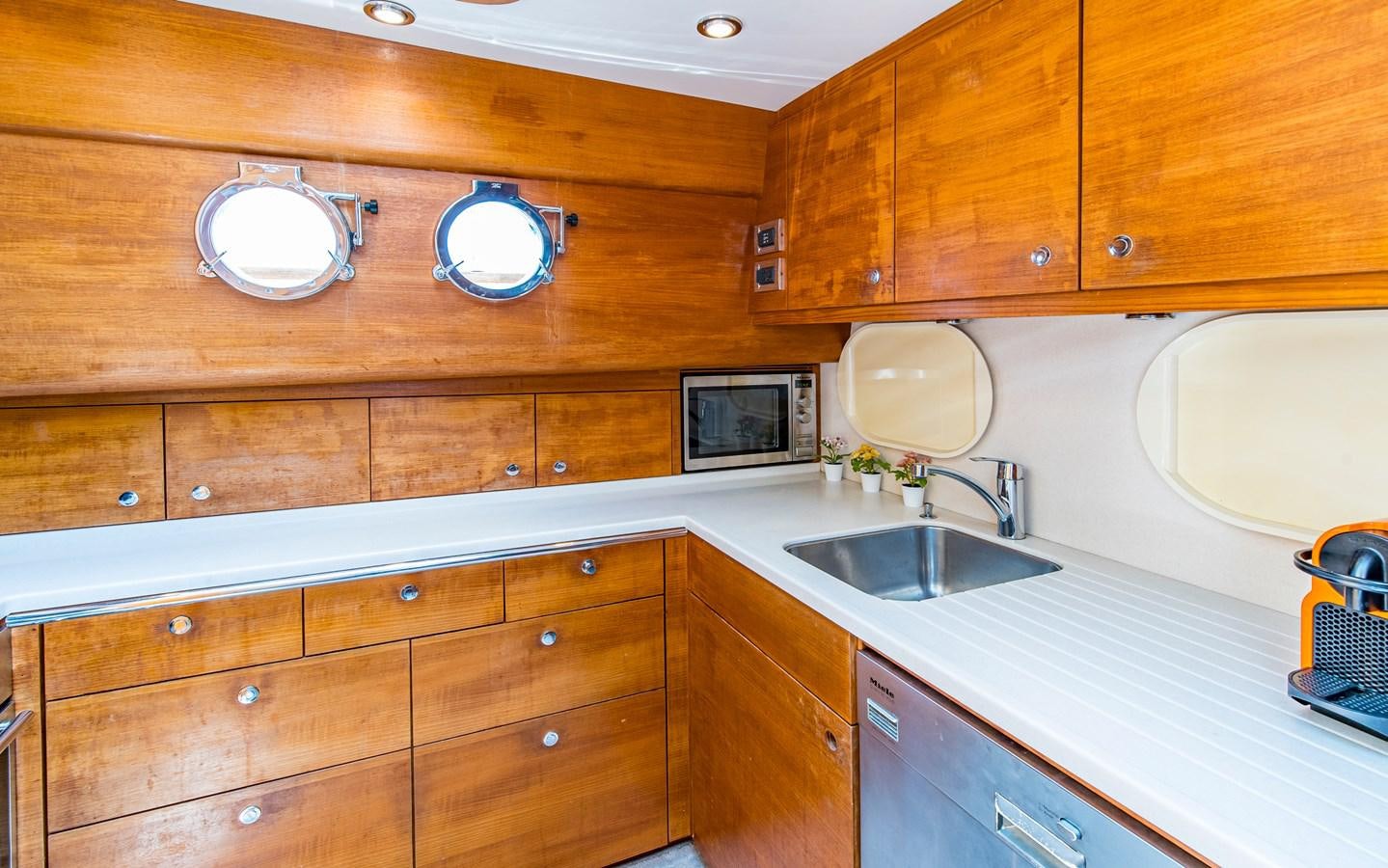 a kitchen with wooden cabinets aboard PARODIA Yacht for Sale