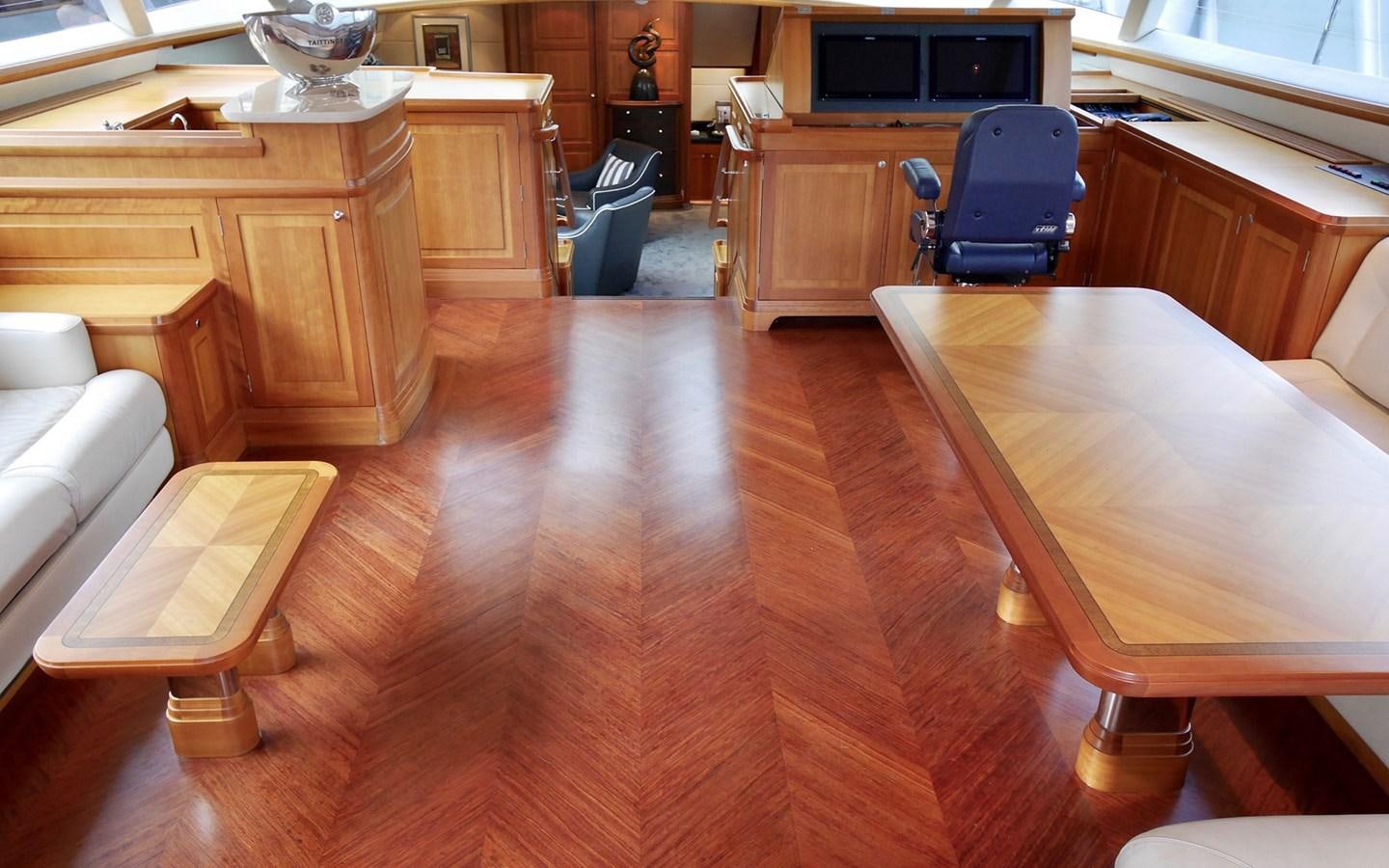 a room with a wood floor and a desk with a chair and a tv on it aboard KOKOTEA Yacht for Sale