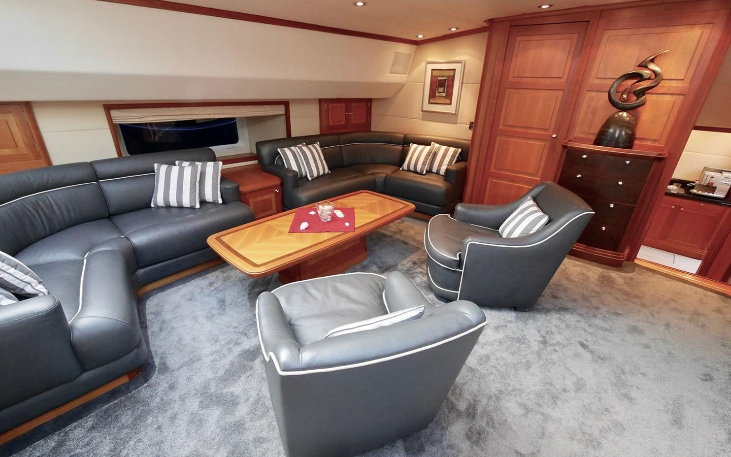 a living room with leather couches and a coffee table aboard KOKOTEA Yacht for Sale