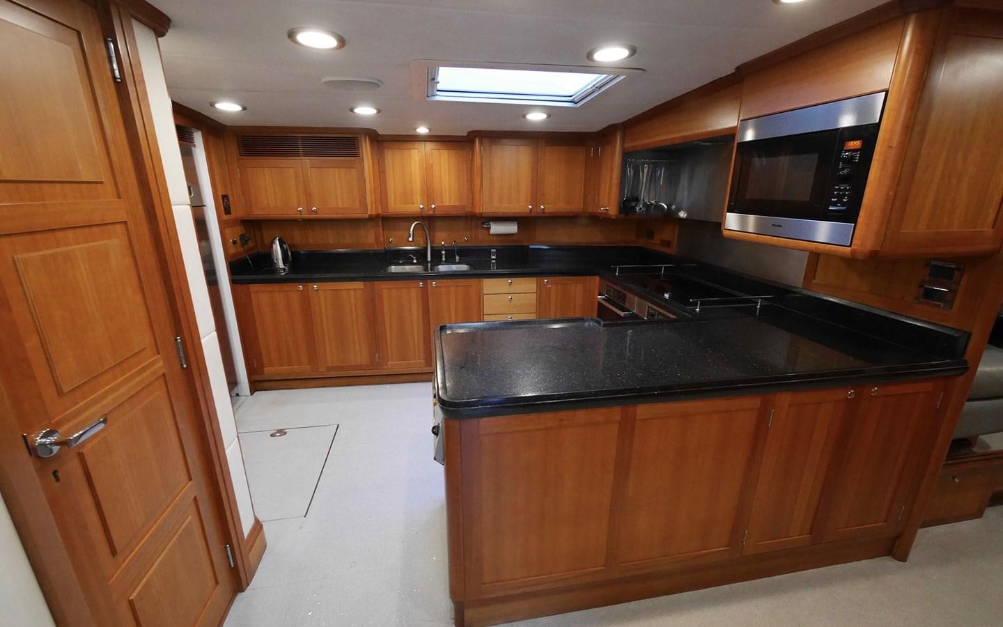 a kitchen with wooden cabinets aboard KOKOTEA Yacht for Sale