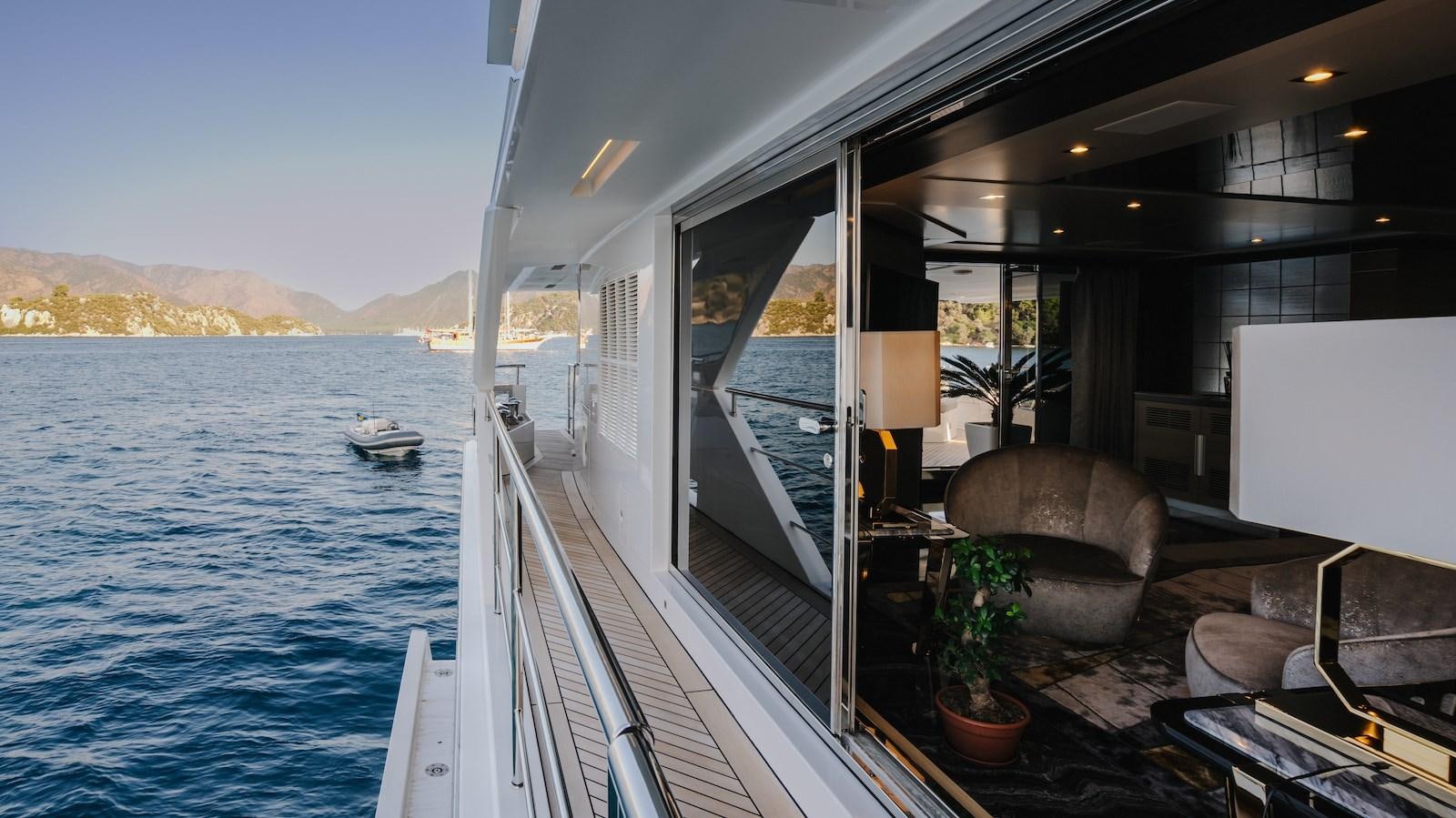 a balcony with a chair and a table on the deck aboard CHARISMA Yacht for Sale