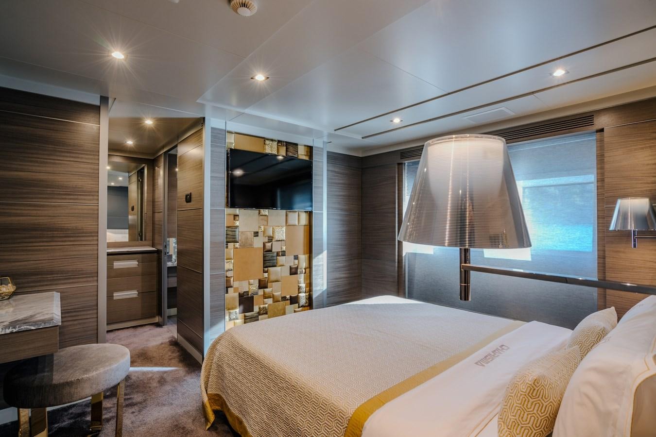 a bedroom with a bed and a lamp aboard CHARISMA Yacht for Sale