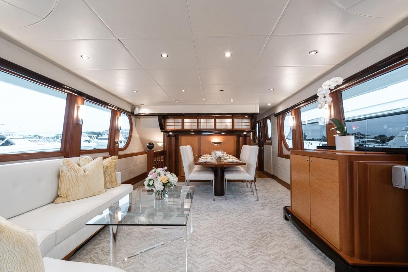 a living room with a table and couches aboard HAPPINESS II Yacht for Sale