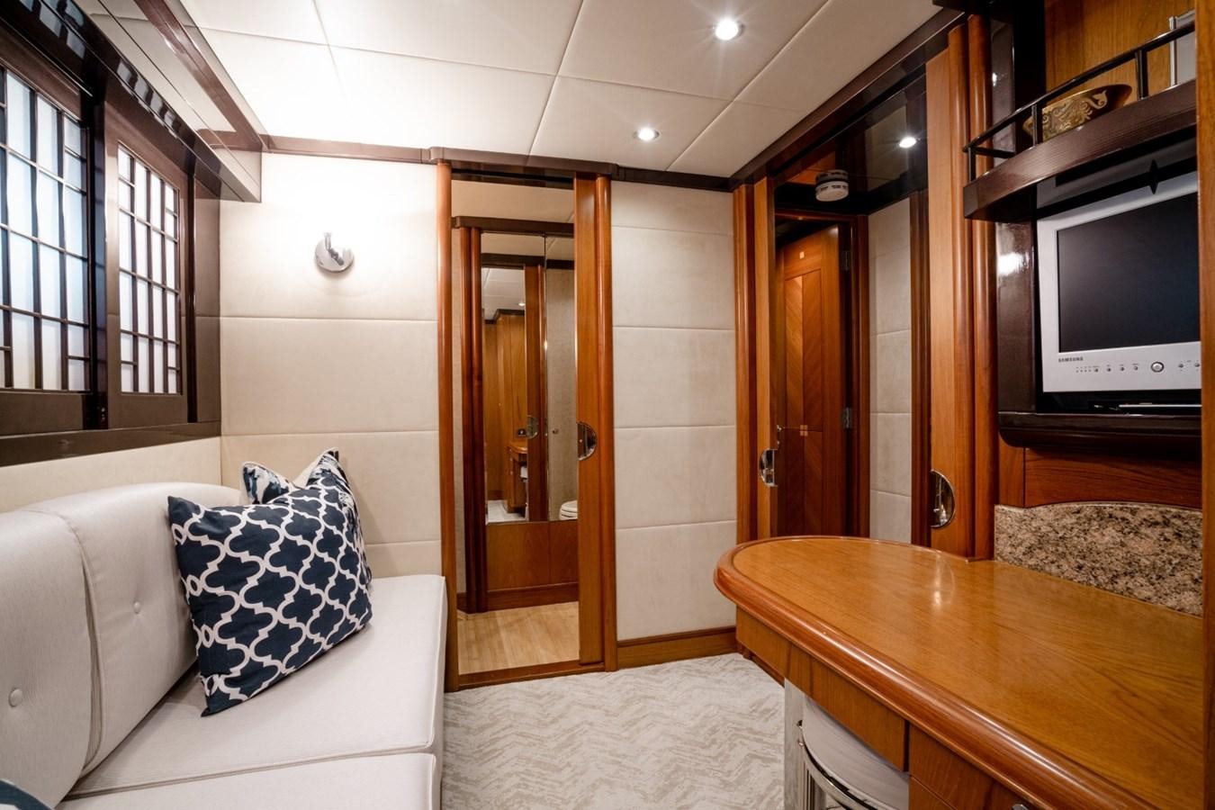 a living room with a tv and a table aboard HAPPINESS II Yacht for Sale
