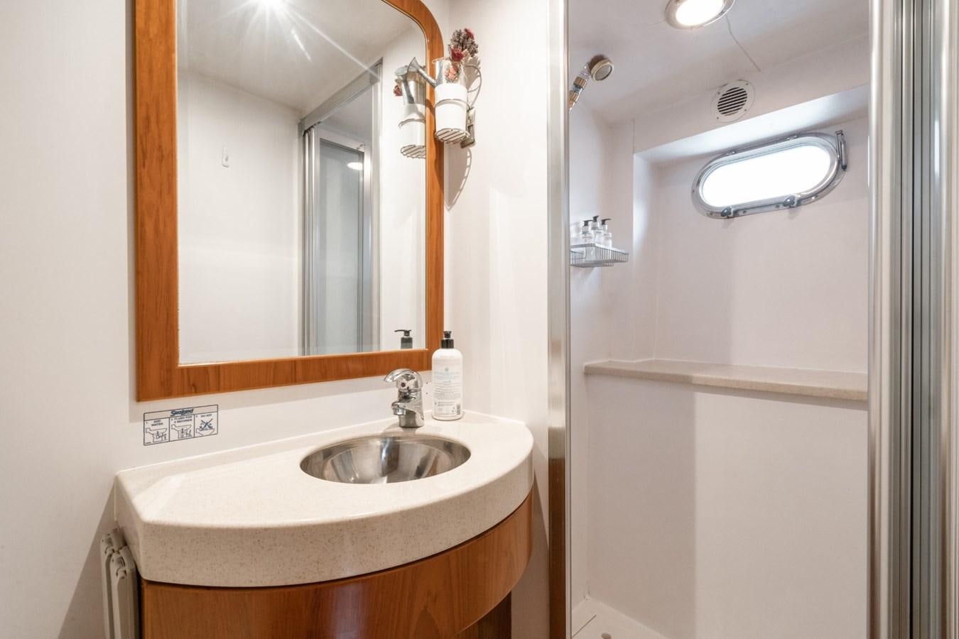 a bathroom with a sink and mirror aboard HAPPINESS II Yacht for Sale