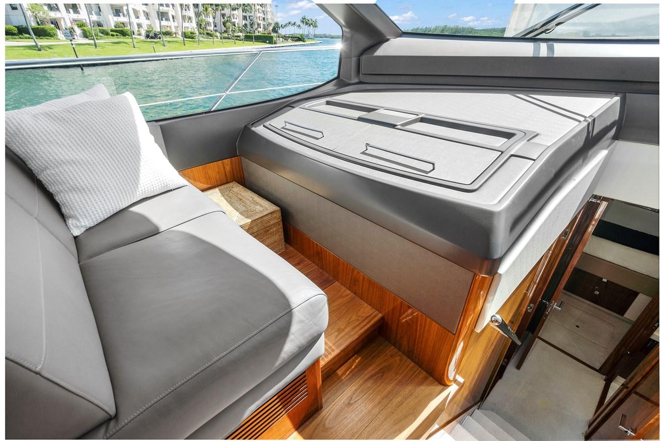a couch and a piano in a room with a pool aboard EXIT Yacht for Sale