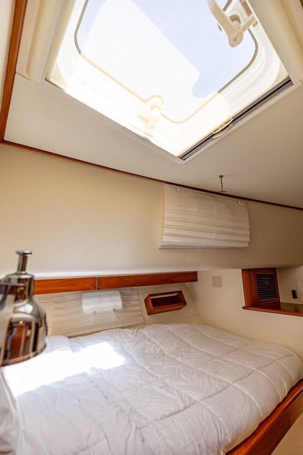 a bed with a bottle and a glass on top aboard SEA BOLD Yacht for Sale
