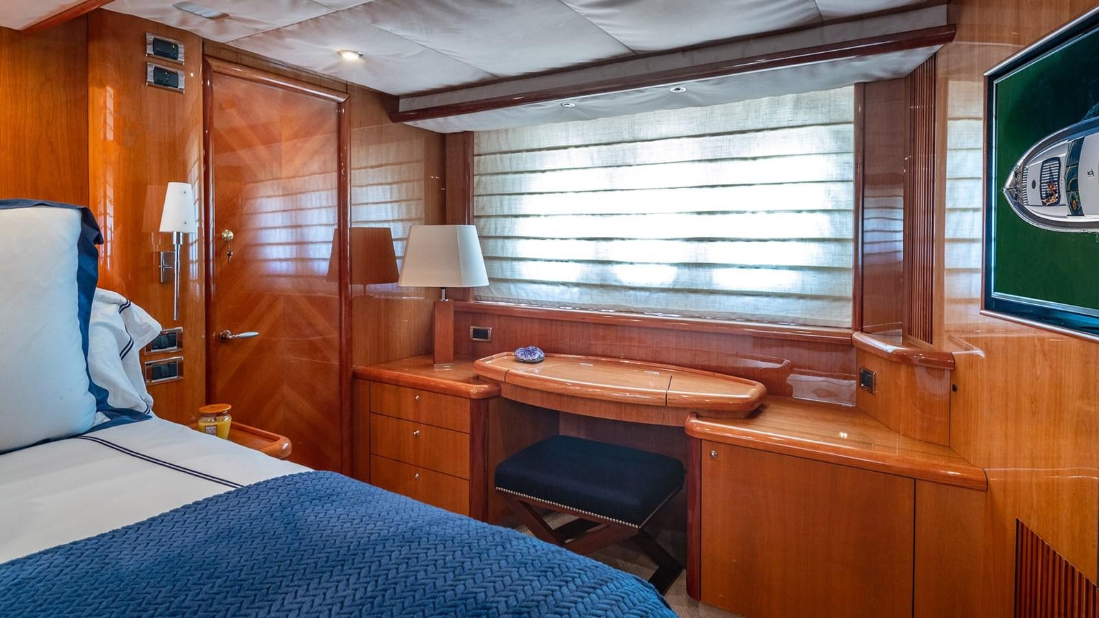 a room with a bed and desk aboard ICONIC Yacht for Sale