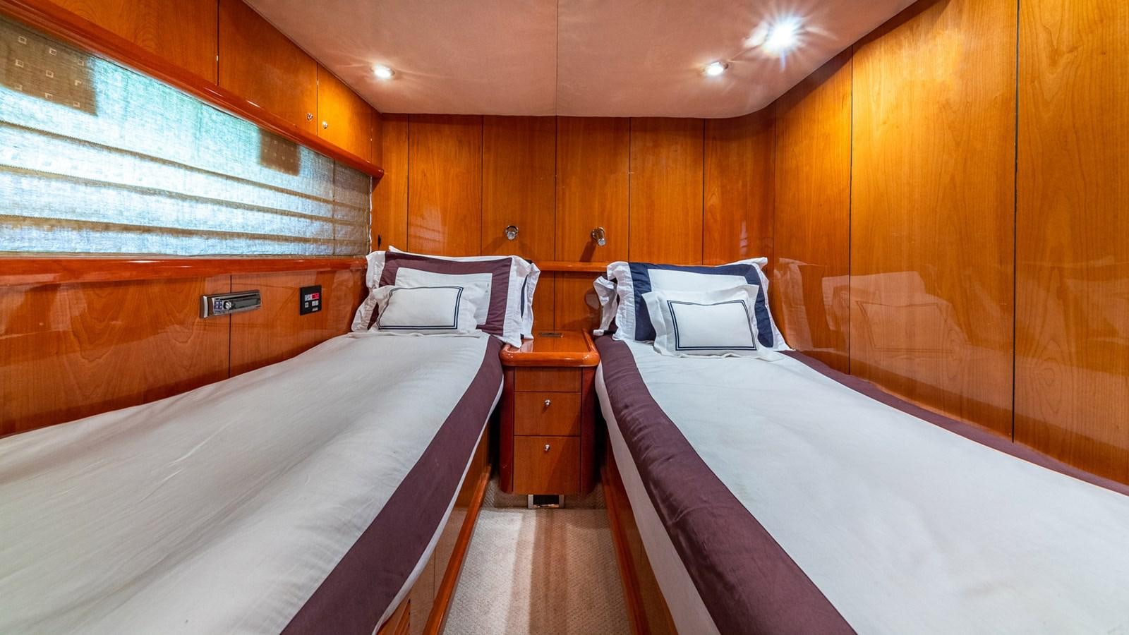 a room with wooden walls and a couple of beds aboard ICONIC Yacht for Sale