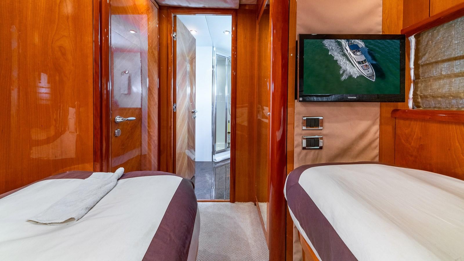 a room with a bed and a television aboard ICONIC Yacht for Sale