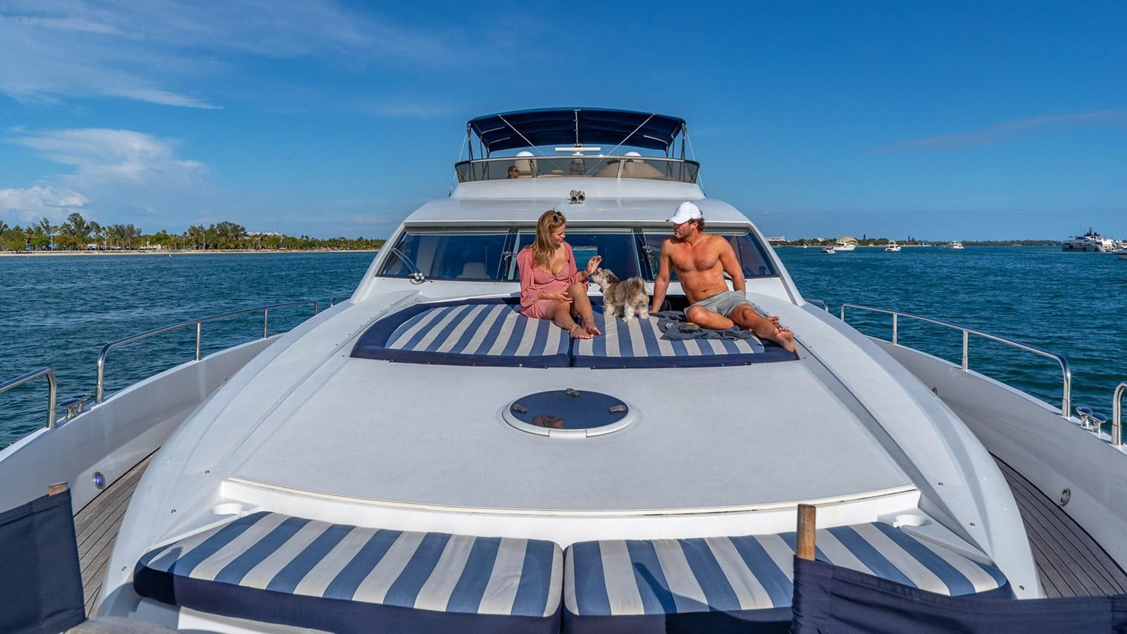 a man and woman and a dog on a boat aboard ICONIC Yacht for Sale