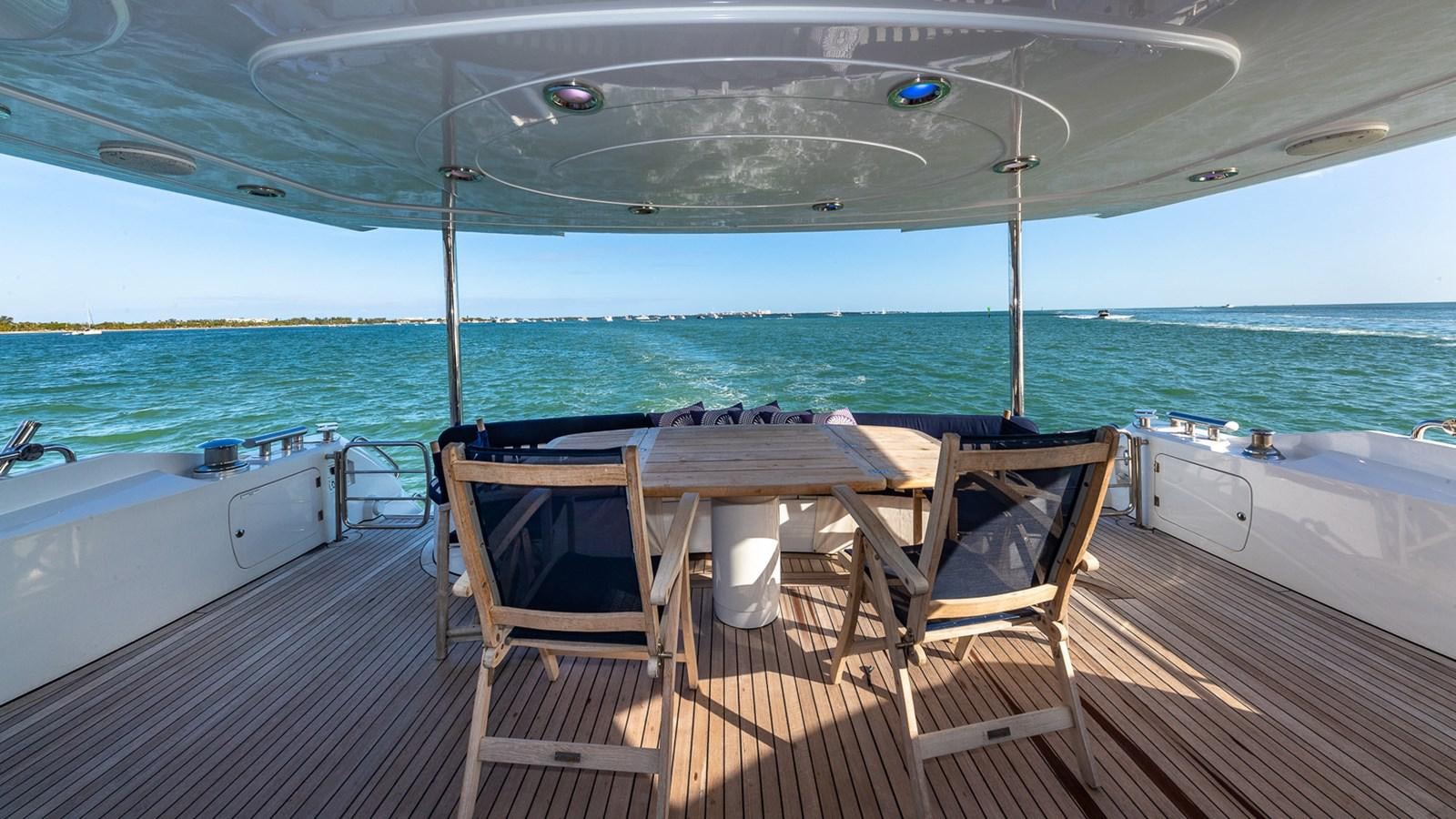 a deck with chairs and a table on it aboard ICONIC Yacht for Sale