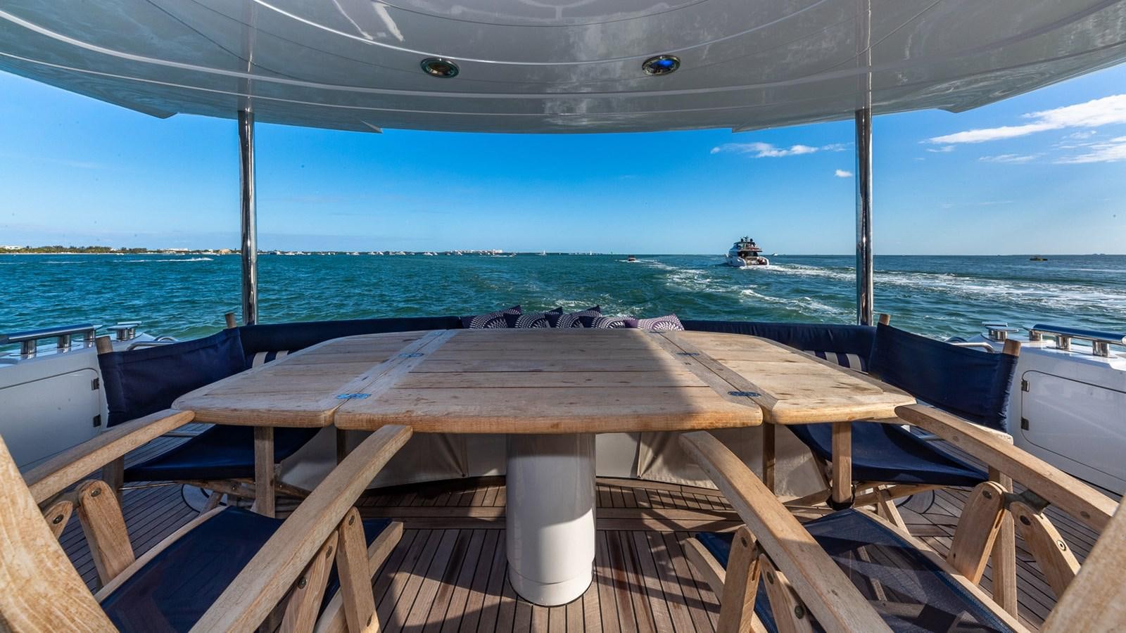 a deck with a view of the ocean and boats aboard ICONIC Yacht for Sale