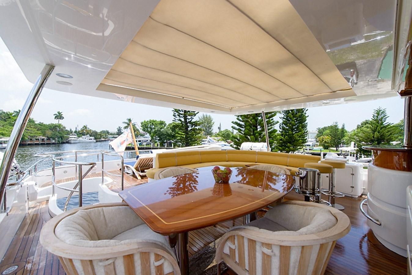 a table and chairs on a deck aboard XOXO Yacht for Sale