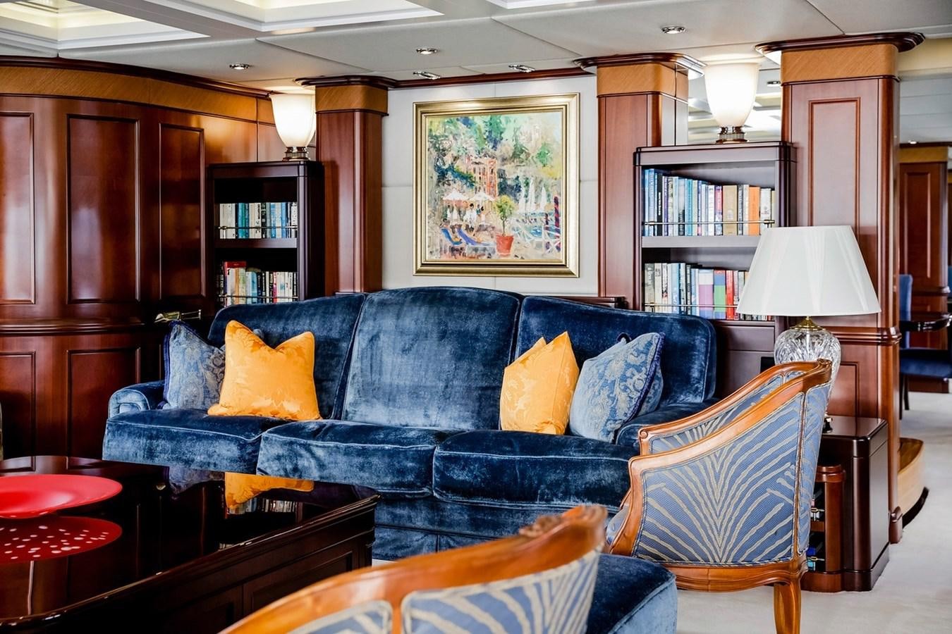 a living room with a blue couch aboard CRYSTAL LADY Yacht for Sale