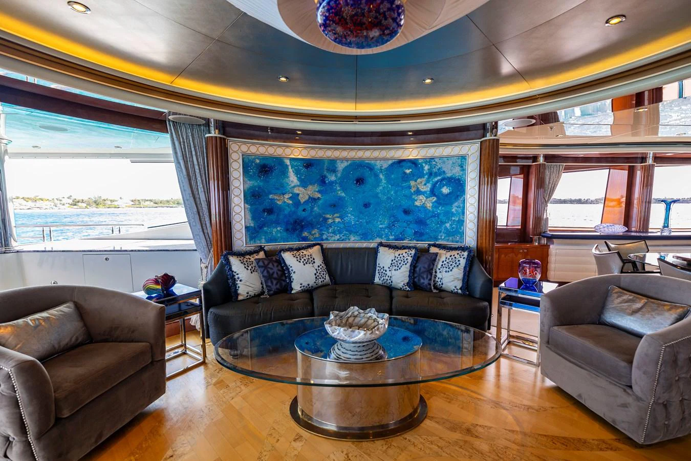 a living room with a large blue couch and a large window aboard ELIS ET MAR Yacht for Sale