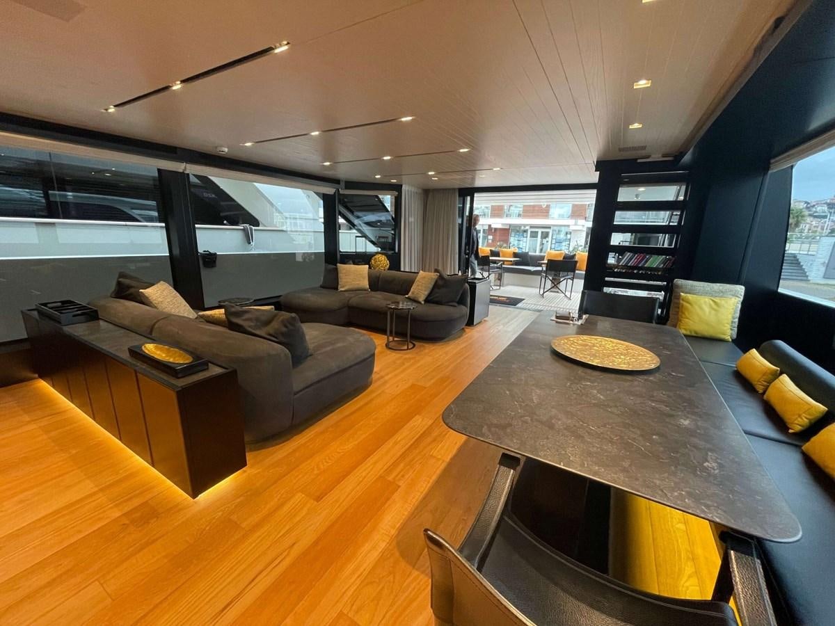 a living room with a large glass table and a large window aboard REINE D'AZUR Yacht for Sale