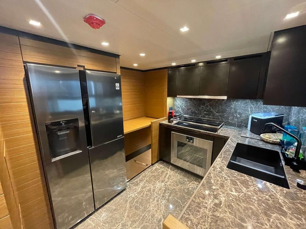 a kitchen with black appliances aboard REINE D'AZUR Yacht for Sale