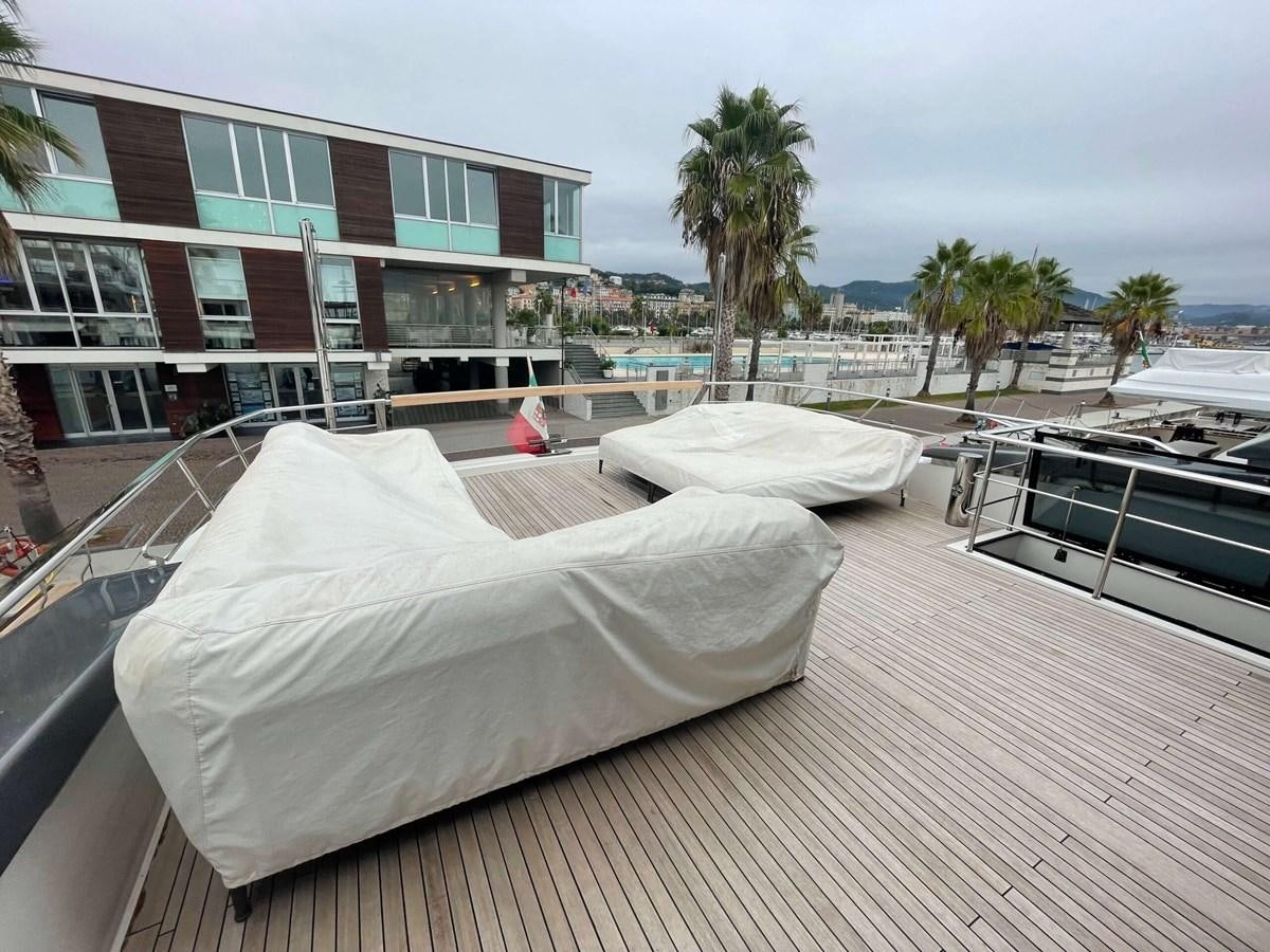 a rooftop with a white sheet over it and a building and palm trees aboard REINE D'AZUR Yacht for Sale