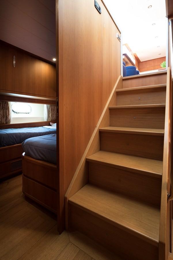 a bunk bed with a wooden headboard aboard ITACATOO Yacht for Sale