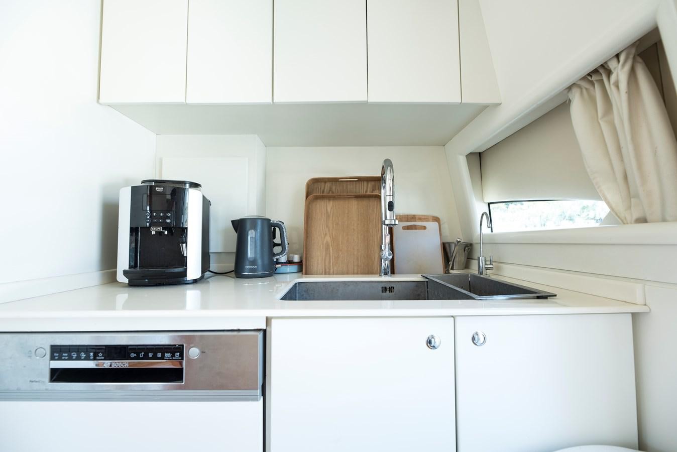 a kitchen with white cabinets aboard ITACATOO Yacht for Sale