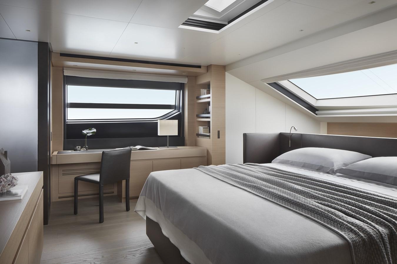 a bedroom with a bed and a desk aboard STRADODO Yacht for Sale